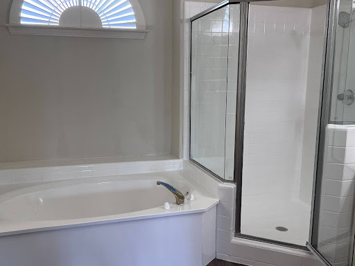 image of a bathtub and shower that were refinished by Ideal Resurfacing and Flooring here in Arlington, Texas. You can see a tub and shower that have been refinished white. The tiles in the shower have also been refinished white.