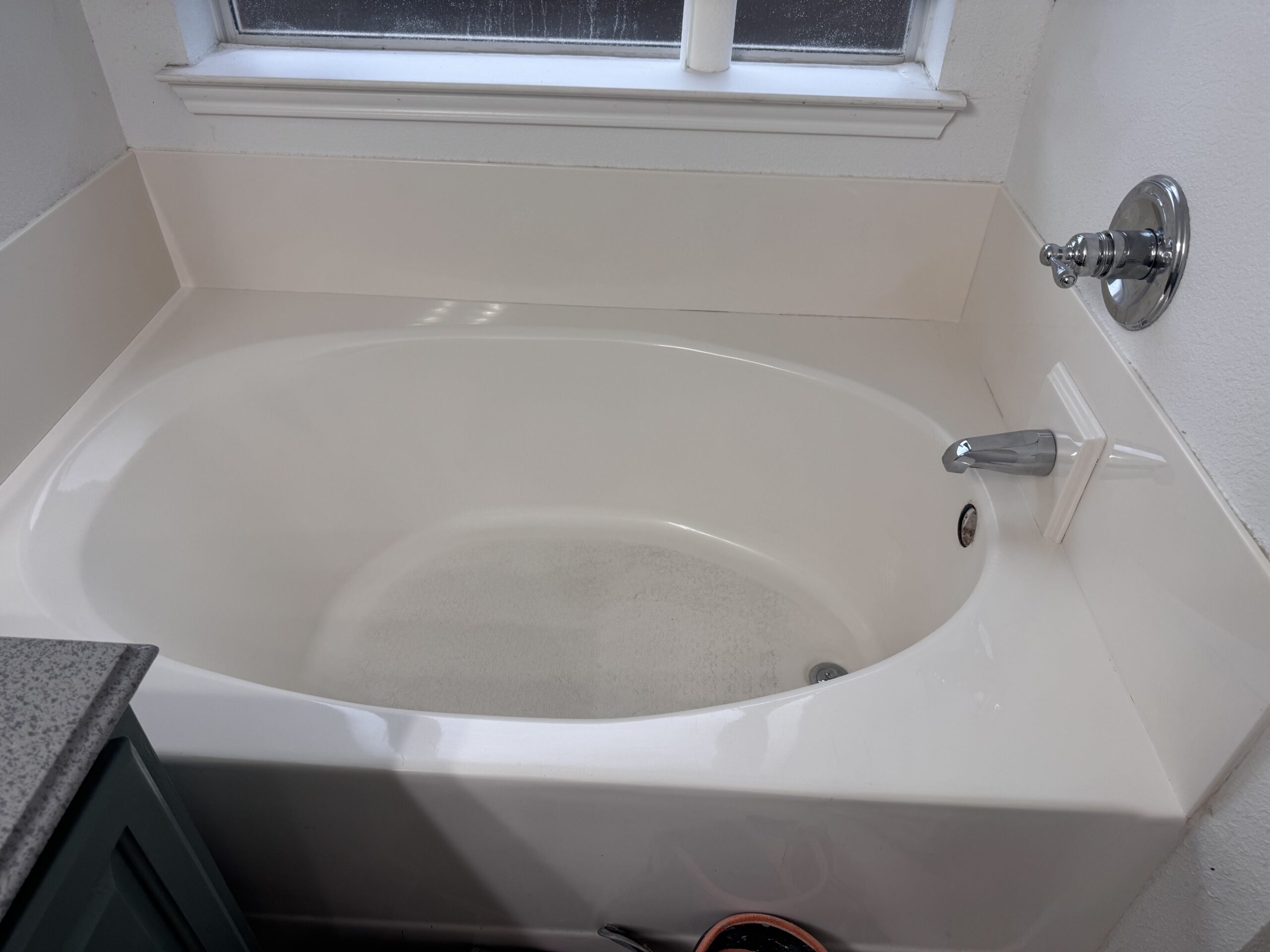 Image of a Refinishing contractors work on a bathtub here in Flower Mound, Texas. You can see the tub has been refinished white.