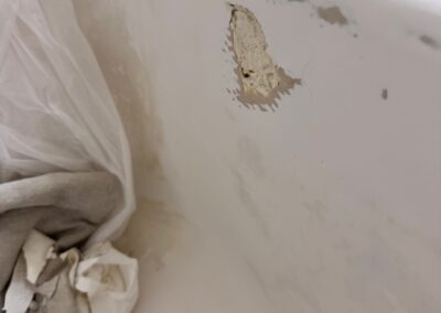 Close-up of a bathtub chip before repair
