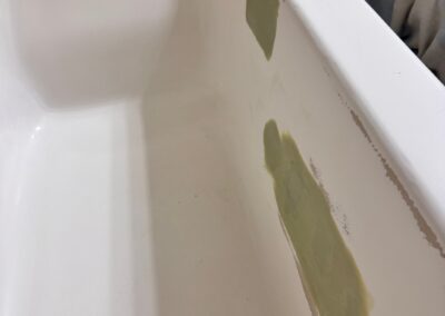 Damaged bathtub surface with repair patches before bathtub refinishing