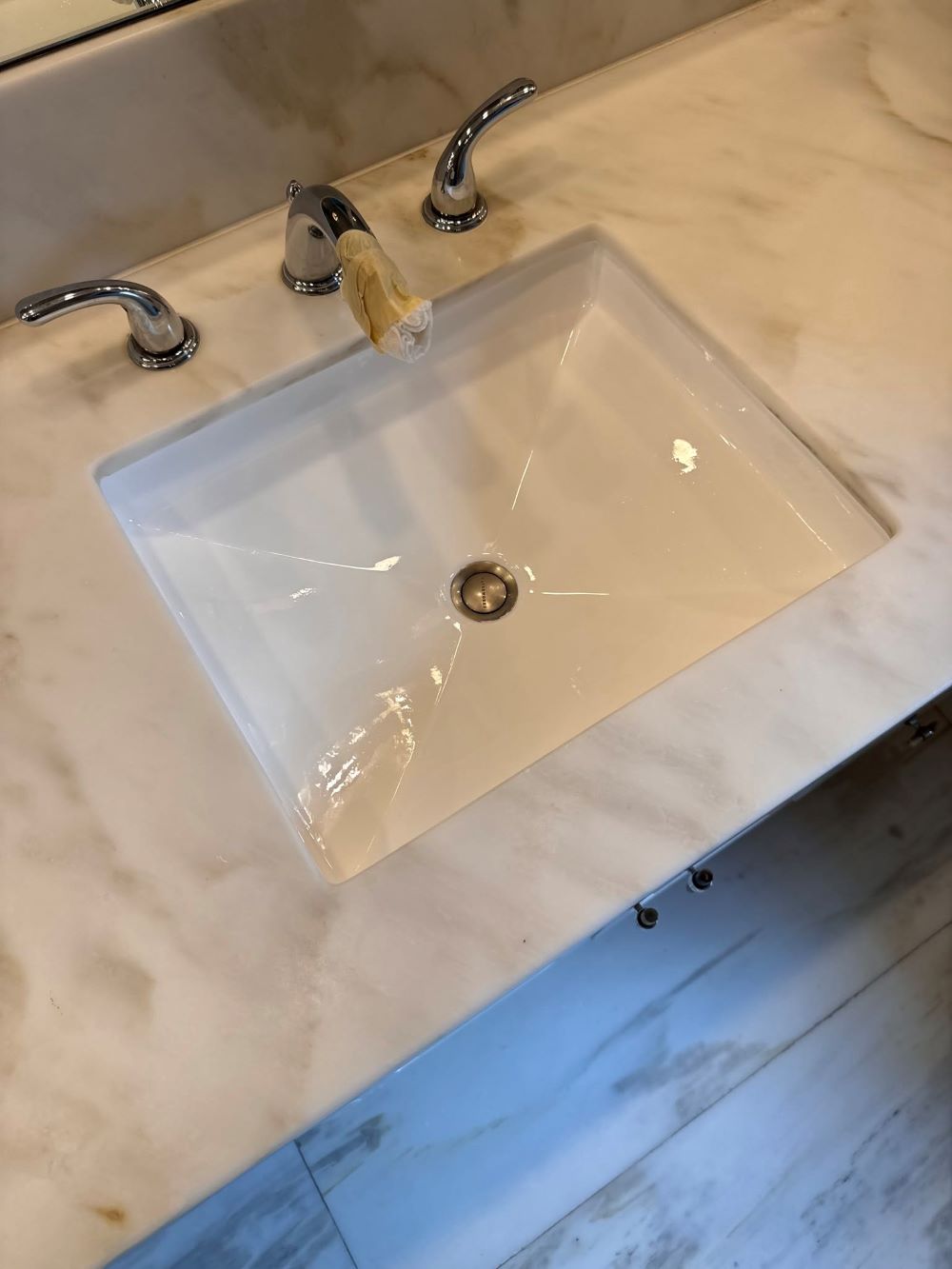 Picture of a sink that has been restored by refinishing. You can see a bathroom sink has has been resurfaced white .