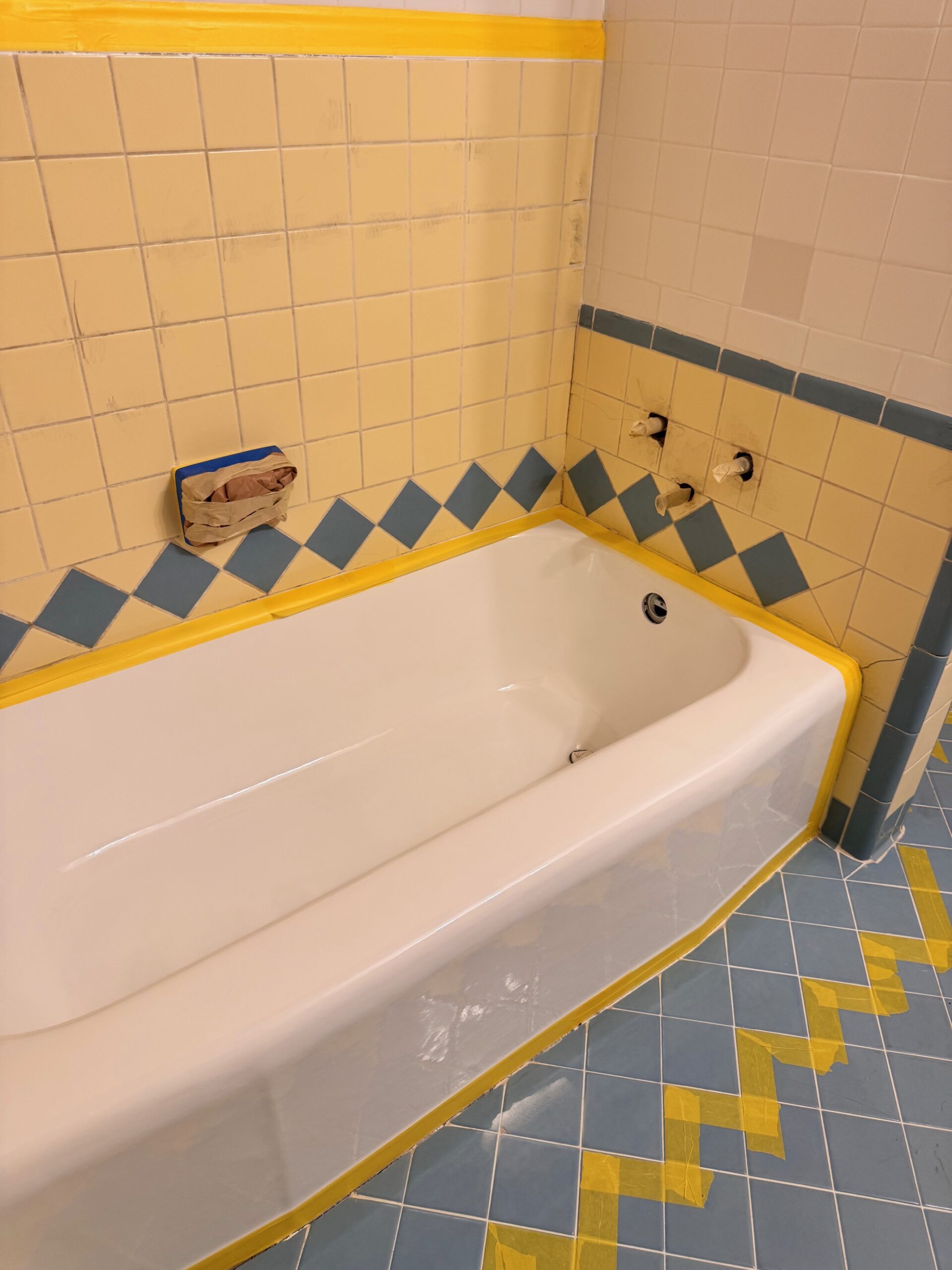 Picture of bathroom tile that has multiple colors. It is getting ready for a tile refinishing job.